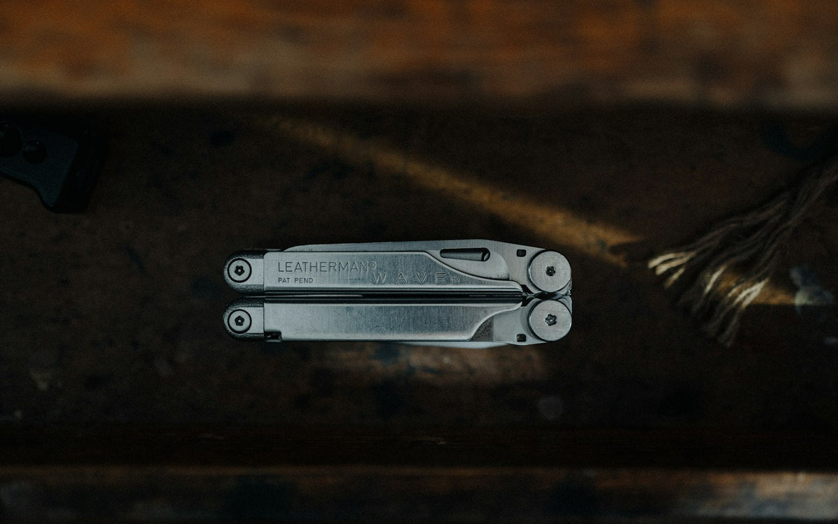 Stainless steel folding multi tool with pliers on a wooden table - EQUIPE Egypt